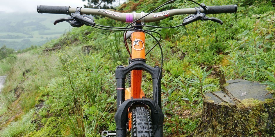 Front view of the Orange bike showing the front suspension forks, handlebars and the Orange logo on the front of the frame